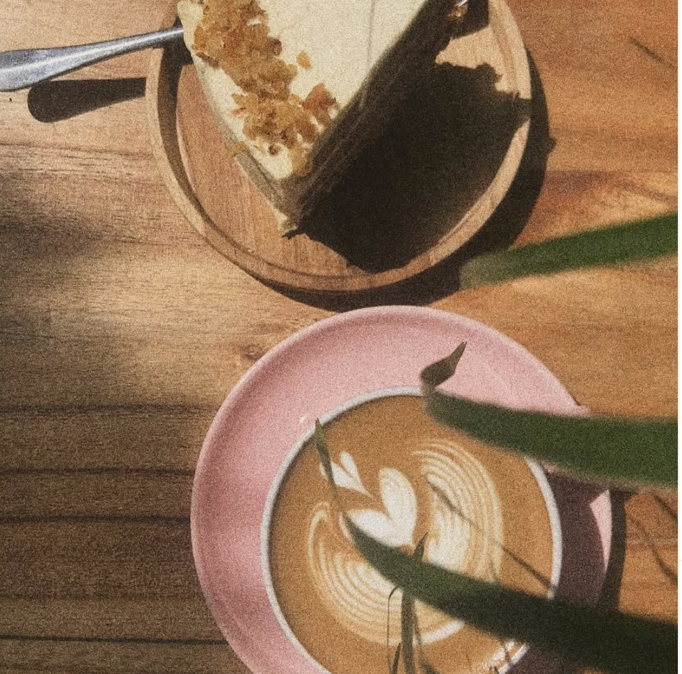 Cake slice and latte art on wooden table